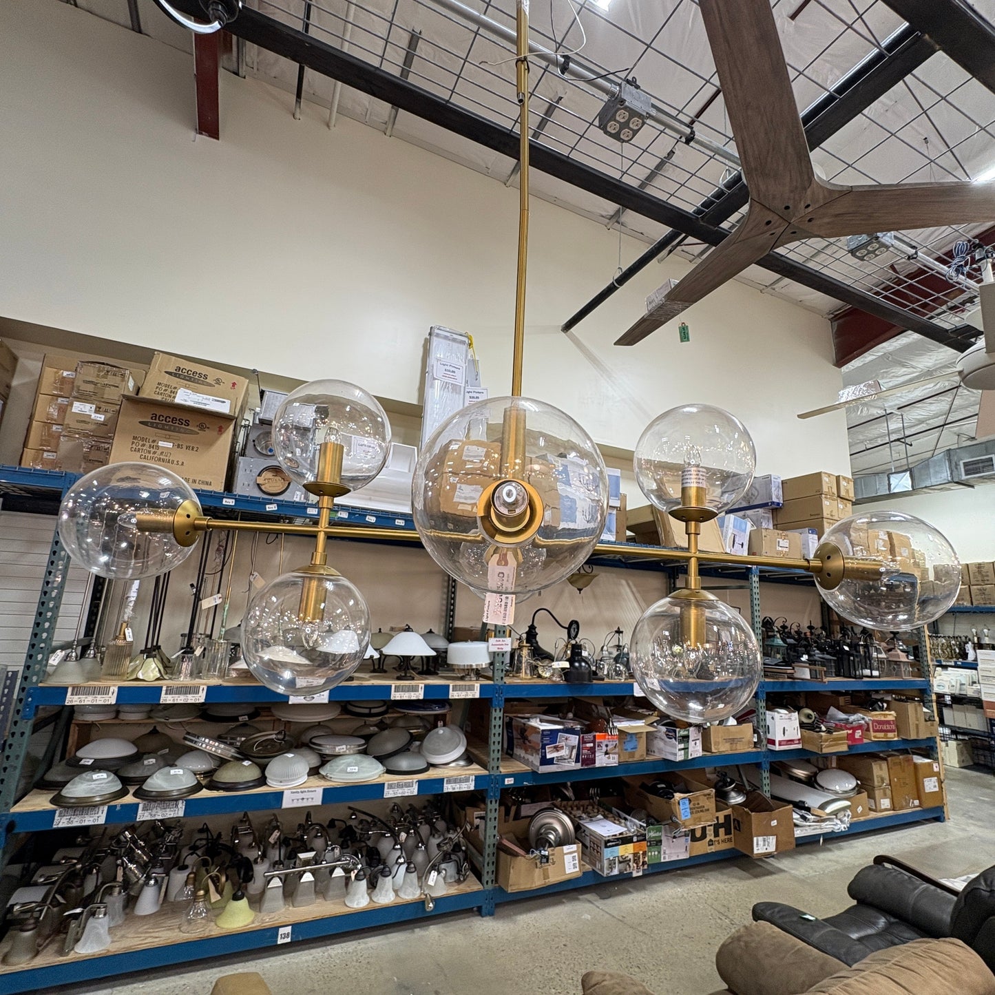 GDM Habitat for Humanity ReStore modern gold chandelier with six clear glass globe shades in a retail warehouse