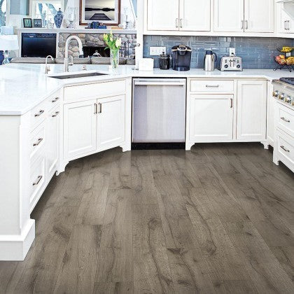 GDM Habitat for Humanity ReStore Hamilton Oak laminate flooring installed in a modern white kitchen with wood grain
