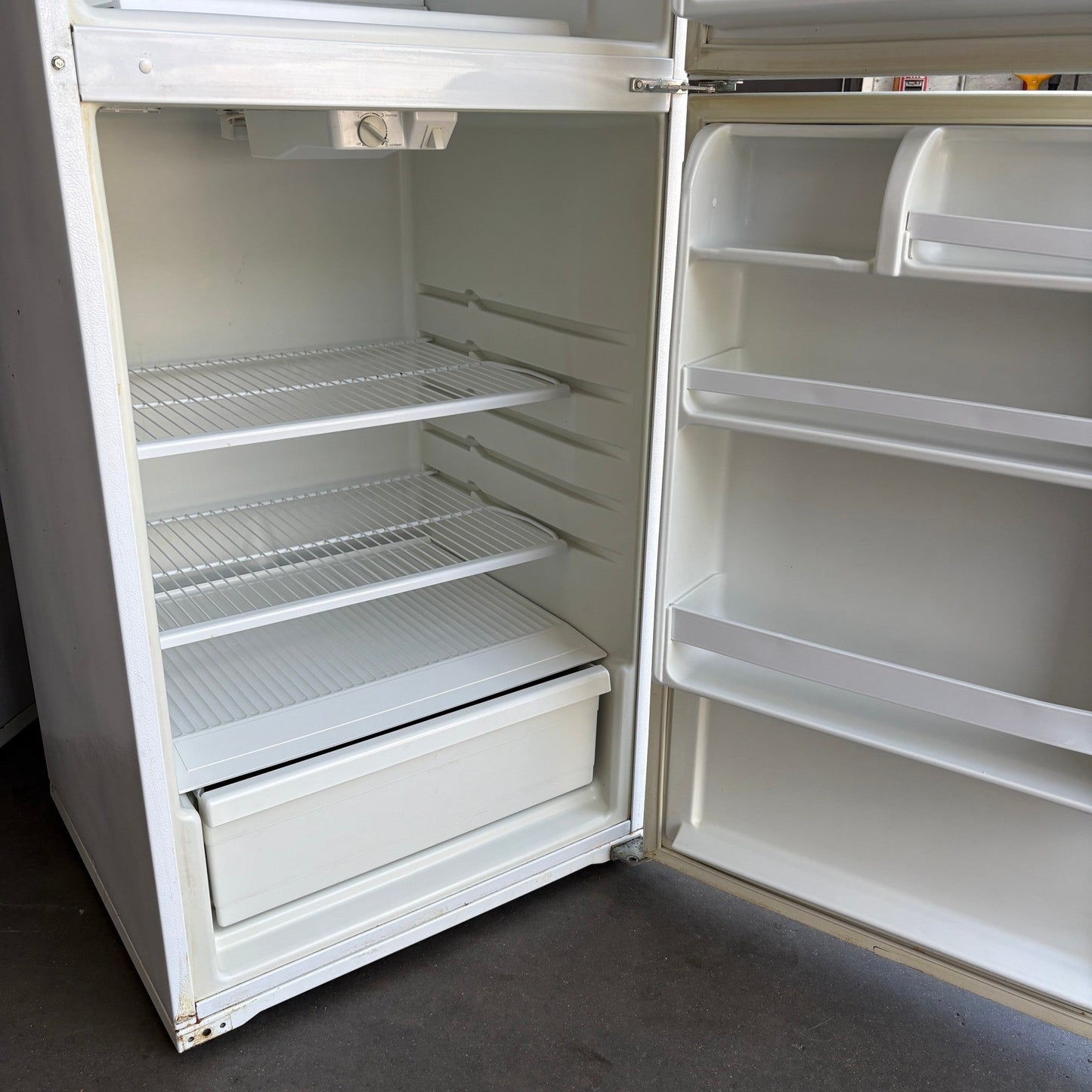 GDM Habitat for Humanity ReStore white Whirlpool top-freezer refrigerator interior with wire shelves and door bins.
