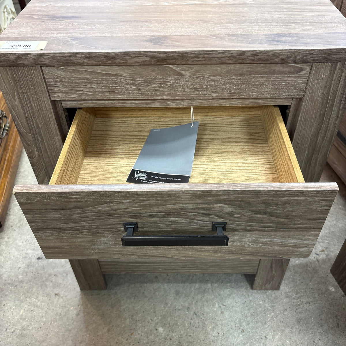 Ashley 2 Drawer Night Stand - top drawer open with the warranty hang tag inside
