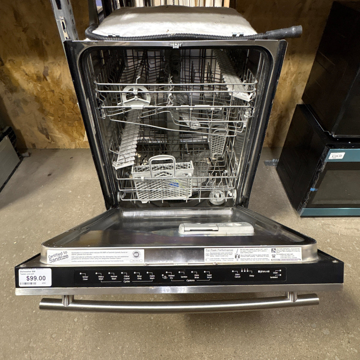 Jenn Air Built In Dishwasher - door open showing the upper and lower wire racks and silverware basket
