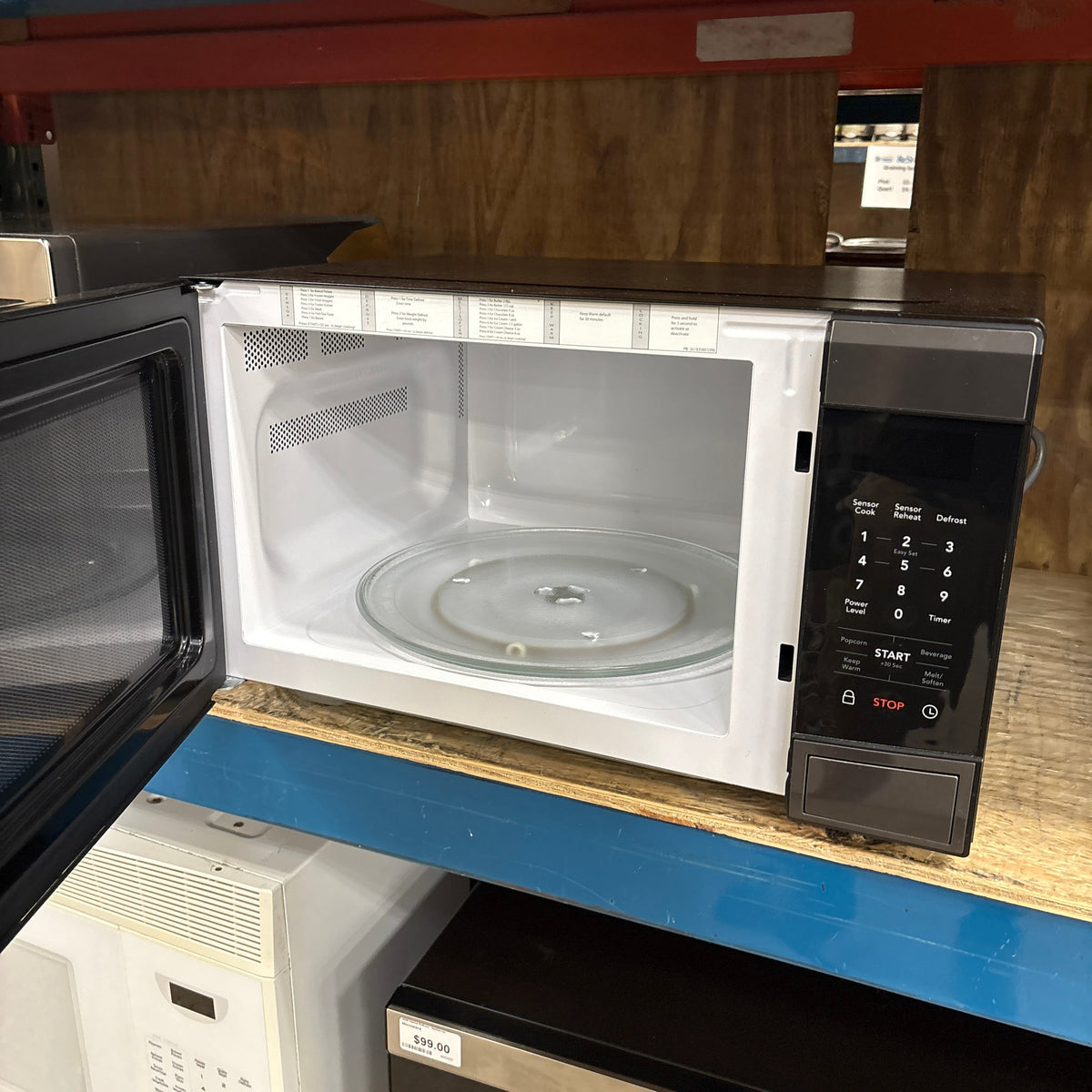 Frigidaire Blk SS Microwave - door open showing the white interior and glass turntable