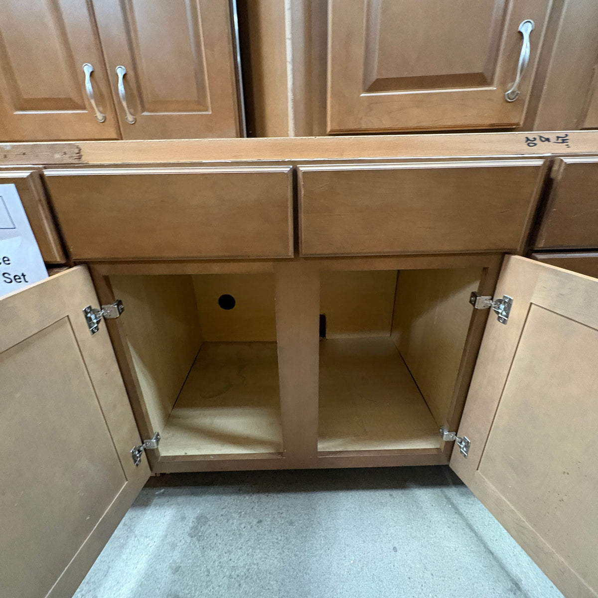 14 Pc Brown Cabinet Set - sink base cabinet open showing the plumbing knockout in the back panel
