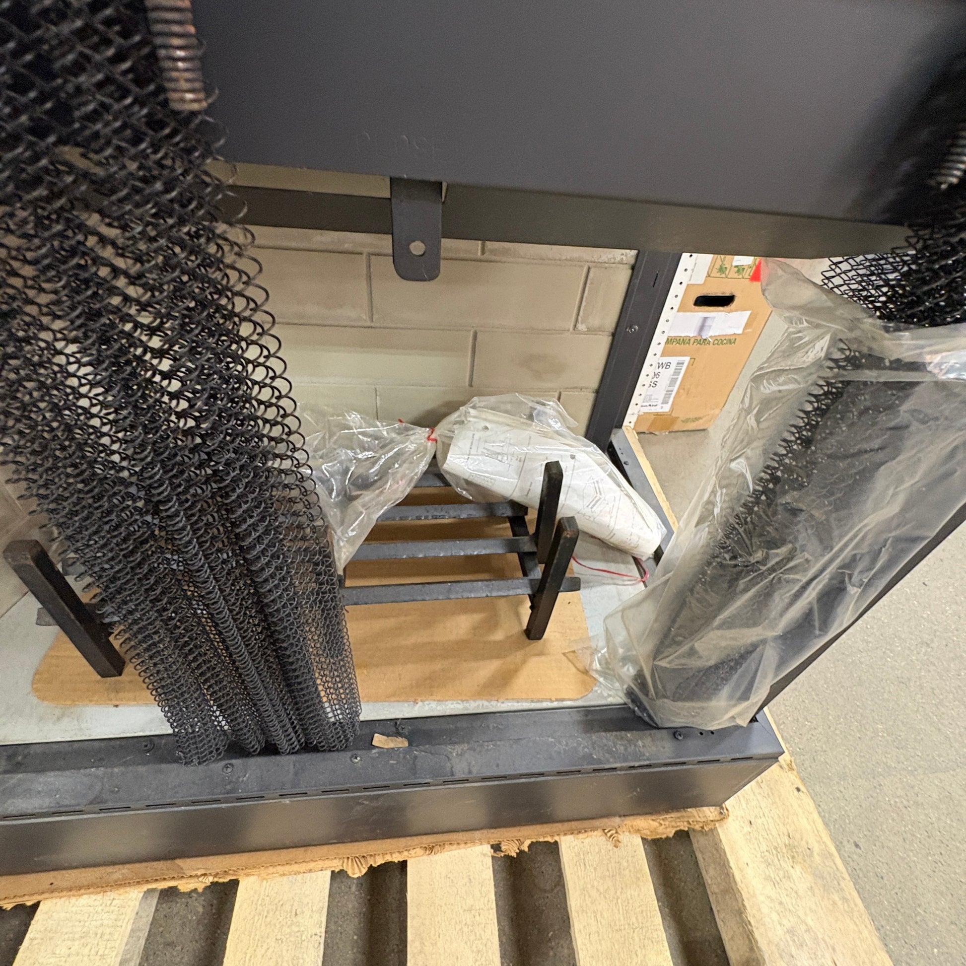 GDM Habitat for Humanity ReStore black metal fireplace screen with mesh curtains and log grate on a wooden pallet