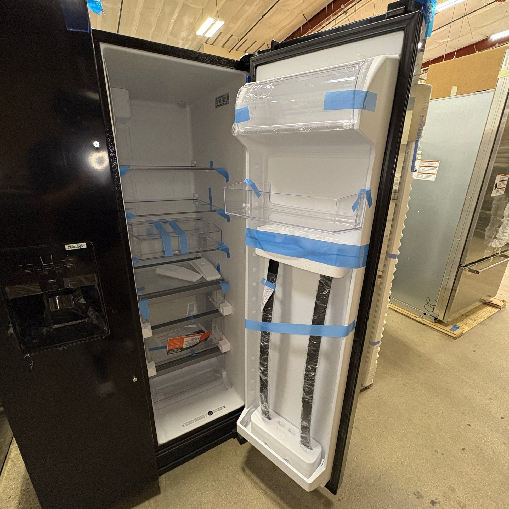 GDM Habitat for Humanity ReStore black Whirlpool side-by-side refrigerator with open door and interior shelving