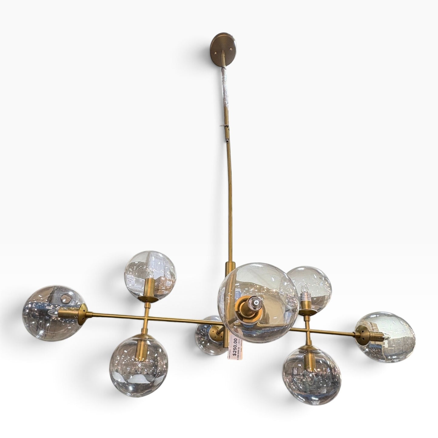 GDM Habitat for Humanity ReStore modern brass chandelier with seven clear glass globe shades on a white background
