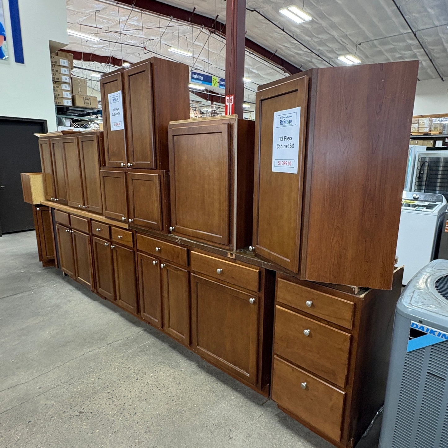 GDM Habitat for Humanity ReStore 13-piece brown wooden kitchen cabinet set with shaker-style doors and metal knobs.