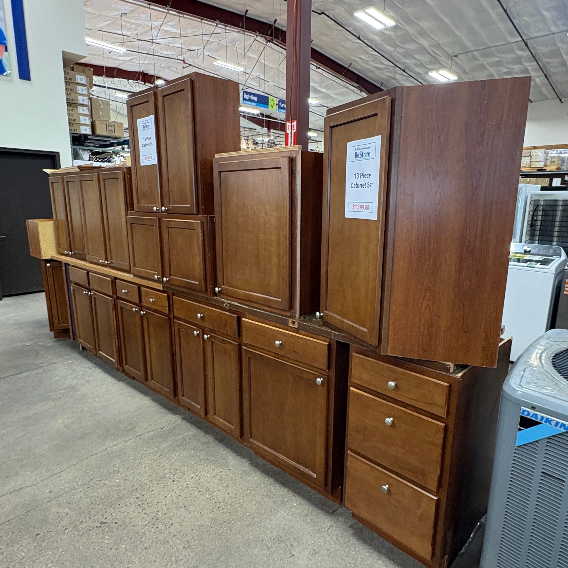 GDM Habitat for Humanity ReStore 13-piece brown wooden kitchen cabinet set with shaker-style doors and metal knobs.