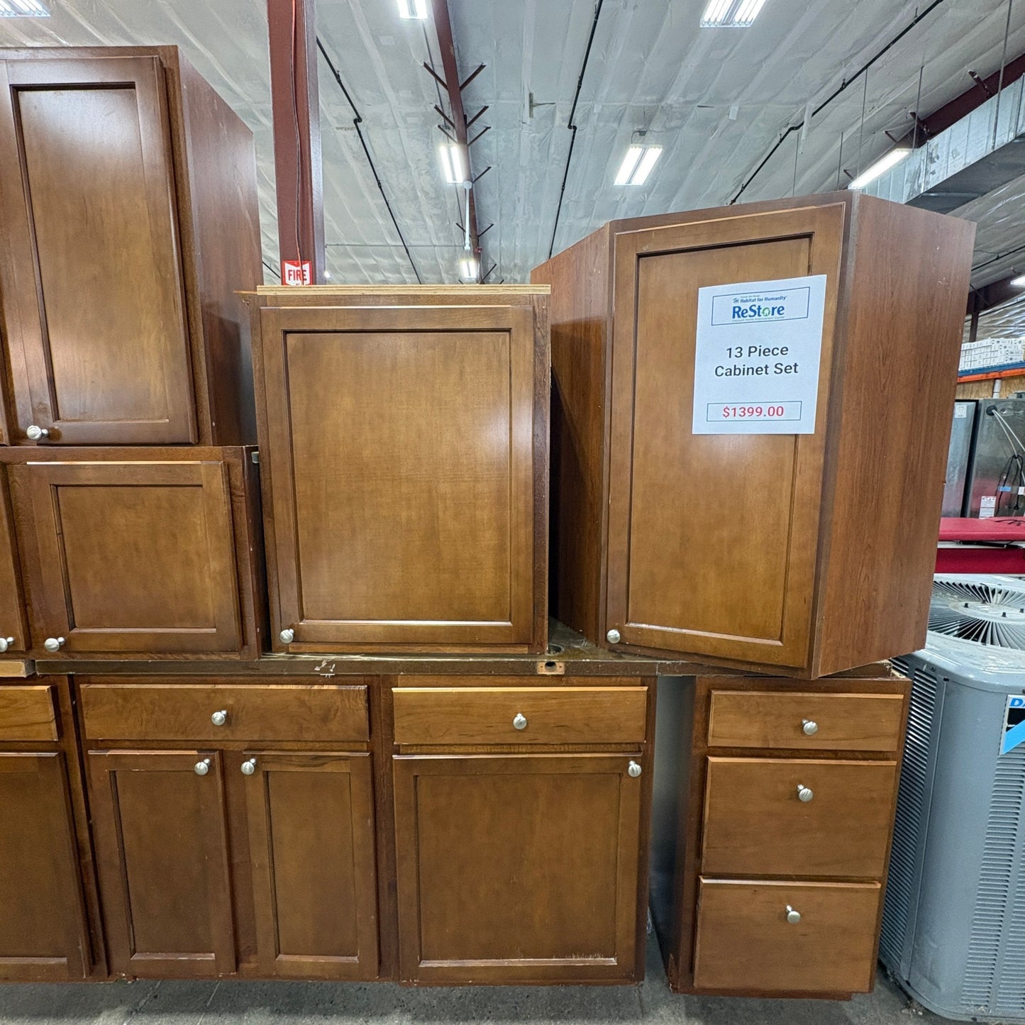 GDM Habitat for Humanity ReStore 13-piece brown wooden kitchen cabinet set with shaker style doors and silver knobs.