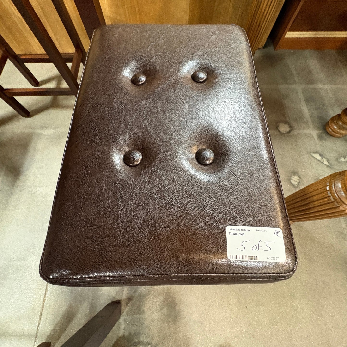 GDM Habitat for Humanity ReStore dark brown faux leather stool with button-tufted detailing from a dining set