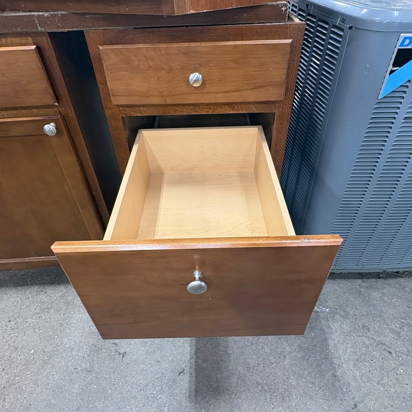 GDM Habitat for Humanity ReStore brown wooden kitchen cabinet with an open drawer featuring a silver knob handle.