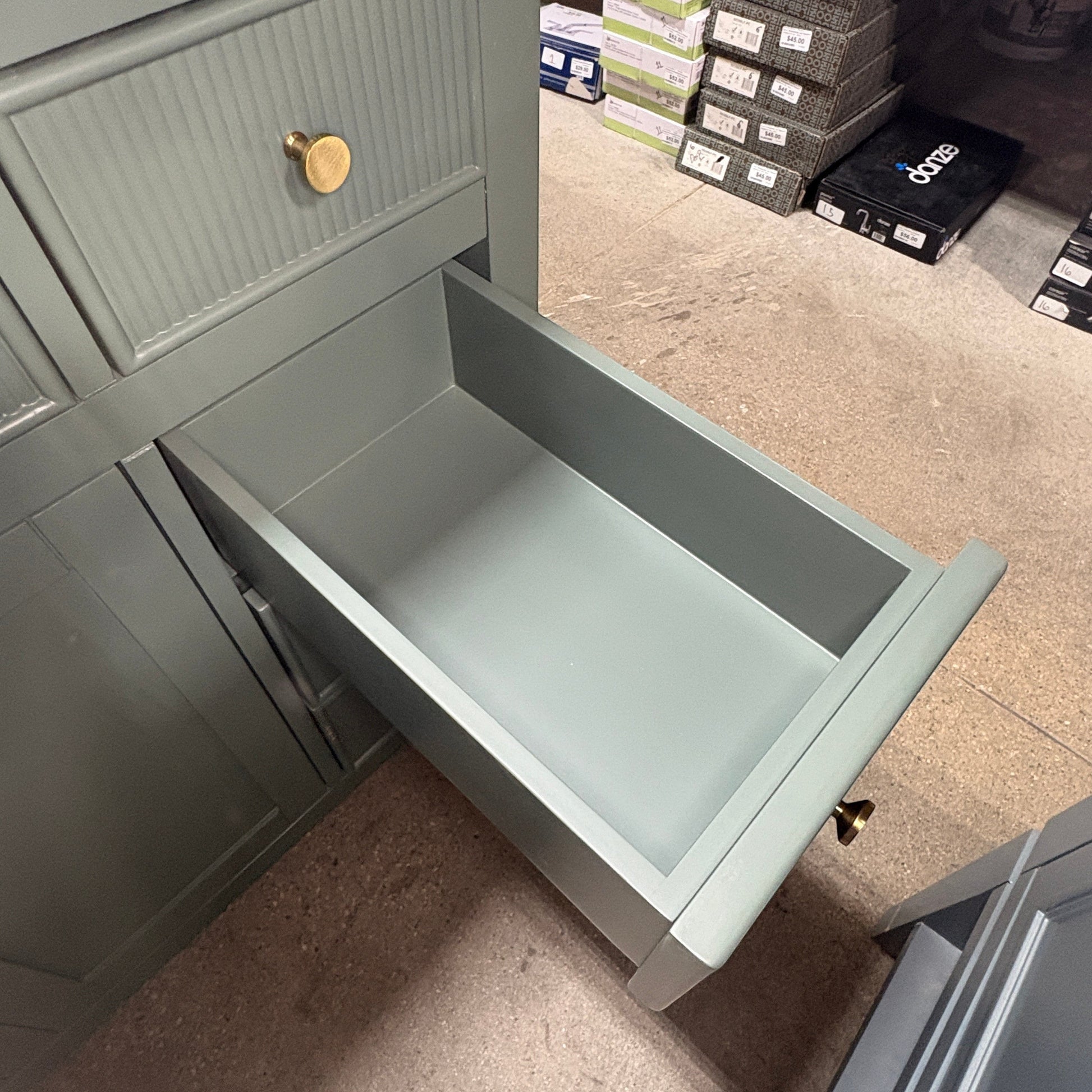 GDM Habitat for Humanity ReStore dark green fluted vanity with an open drawer and a round brass knob