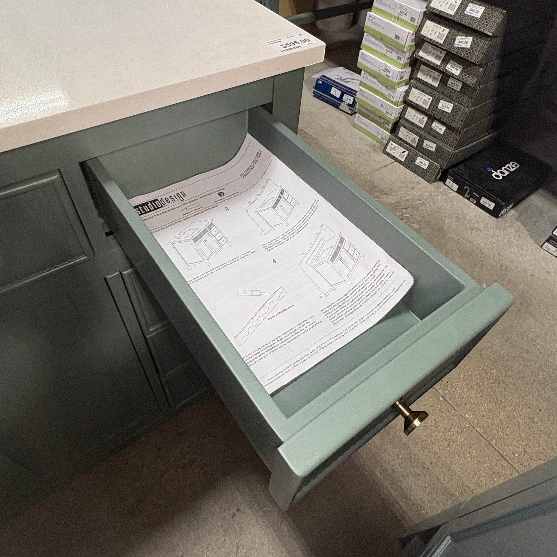 GDM Habitat for Humanity ReStore dark green fluted bathroom vanity with an open drawer and white stone countertop.
