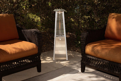GDM Habitat for Humanity ReStore 9500 BTU propane patio heater with stainless steel finish between two wicker chairs