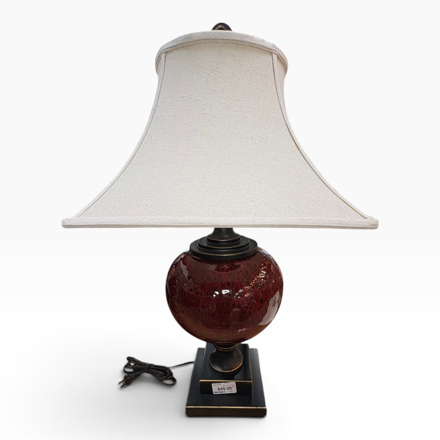 GDM Habitat for Humanity ReStore decorative table lamp with a glossy red ceramic base and off-white fabric shade.