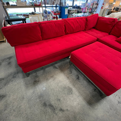 GDM Habitat for Humanity ReStore large red sectional sofa with tufted seat cushions and a matching red ottoman.