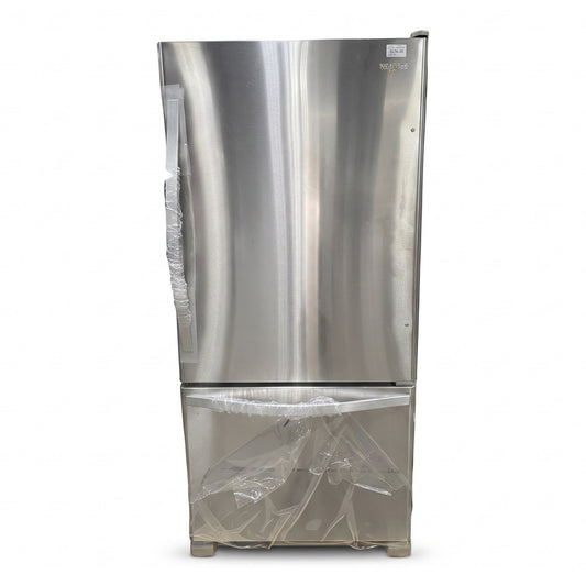 GDM Habitat for Humanity ReStore stainless steel Whirlpool bottom-freezer refrigerator with protective plastic wrap.