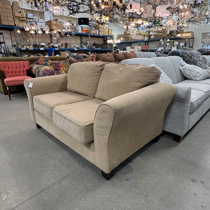 GDM Habitat for Humanity ReStore tan chenille loveseat with plush cushions in a retail furniture showroom setting