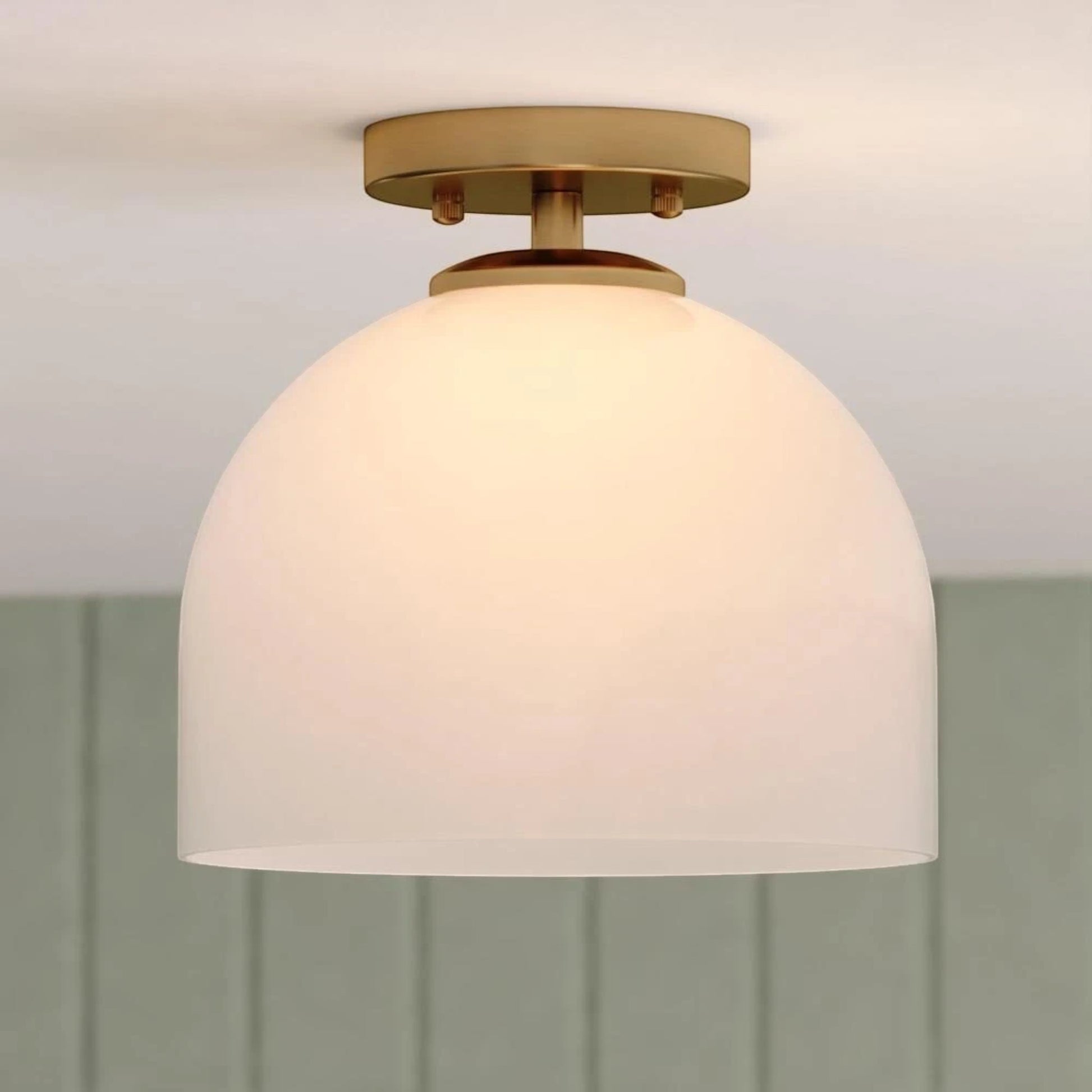 GDM Habitat for Humanity ReStore Vaxcel Shelby ceiling light with a brass finish and a white glass dome shade.