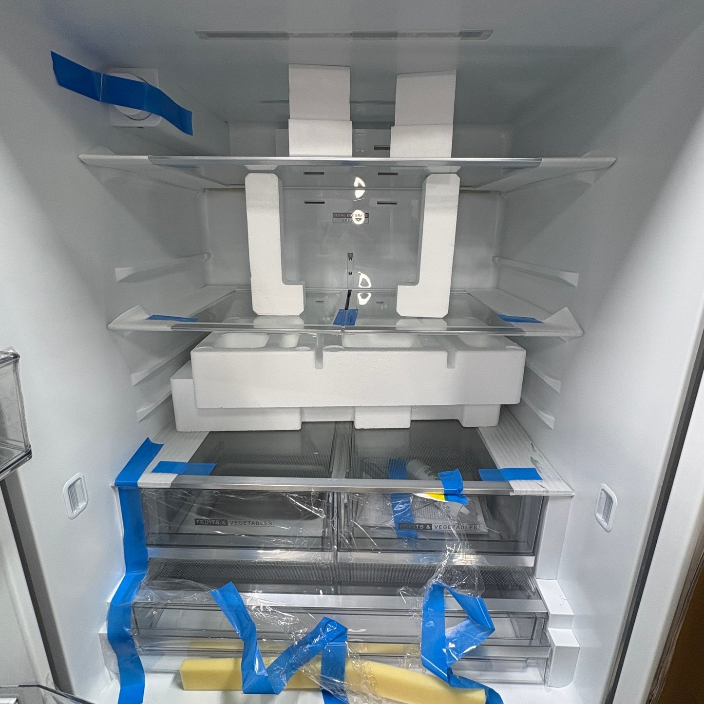 Interior of a new GDM Habitat for Humanity ReStore Whirlpool French door refrigerator with protective foam and tape