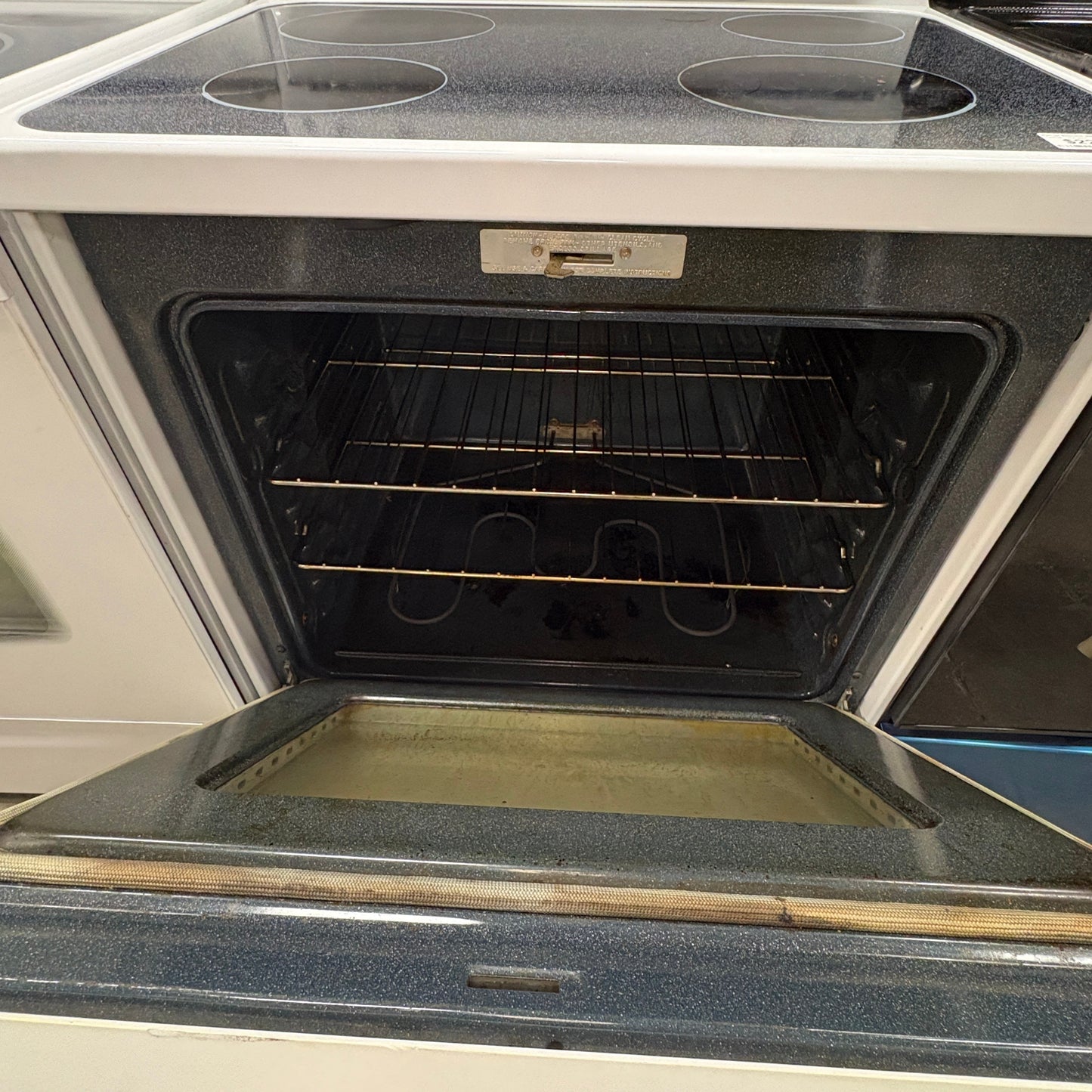 GDM Habitat for Humanity ReStore white GE electric range with glass cooktop and open oven door showing interior racks