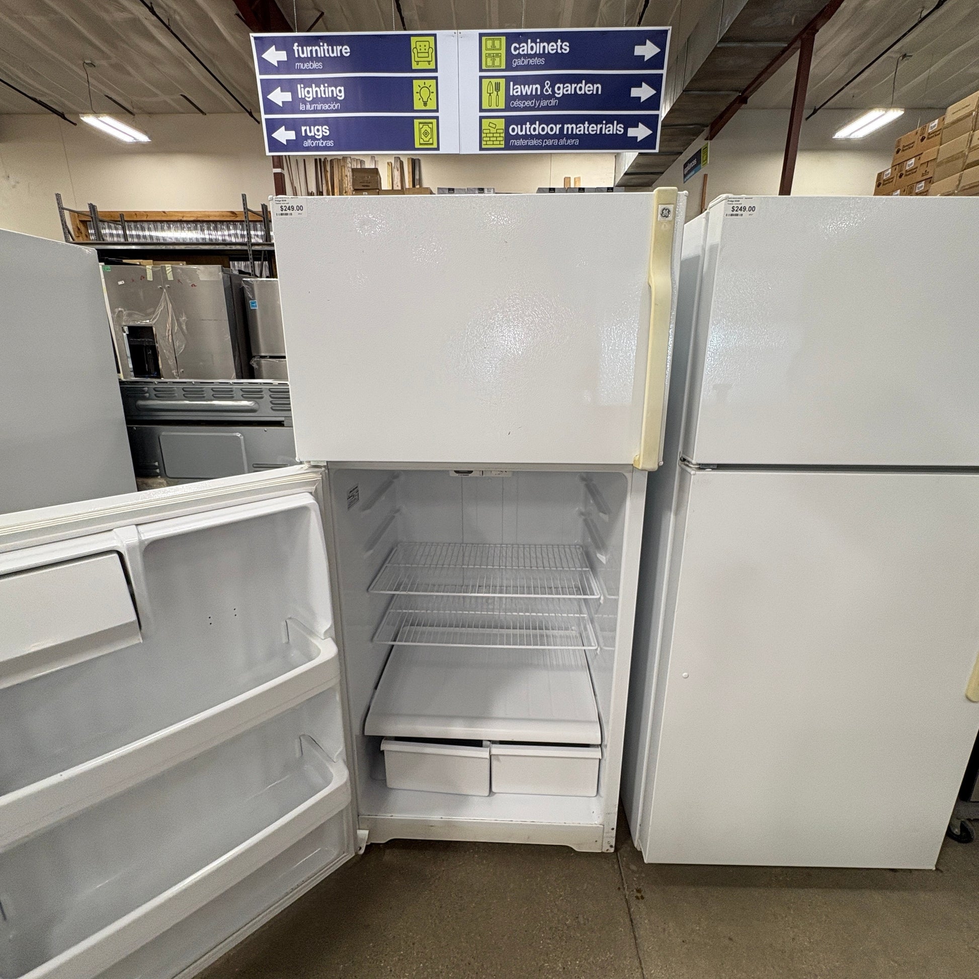 GDM Habitat for Humanity ReStore white GE top-freezer refrigerator with open door and wire shelves in a retail store