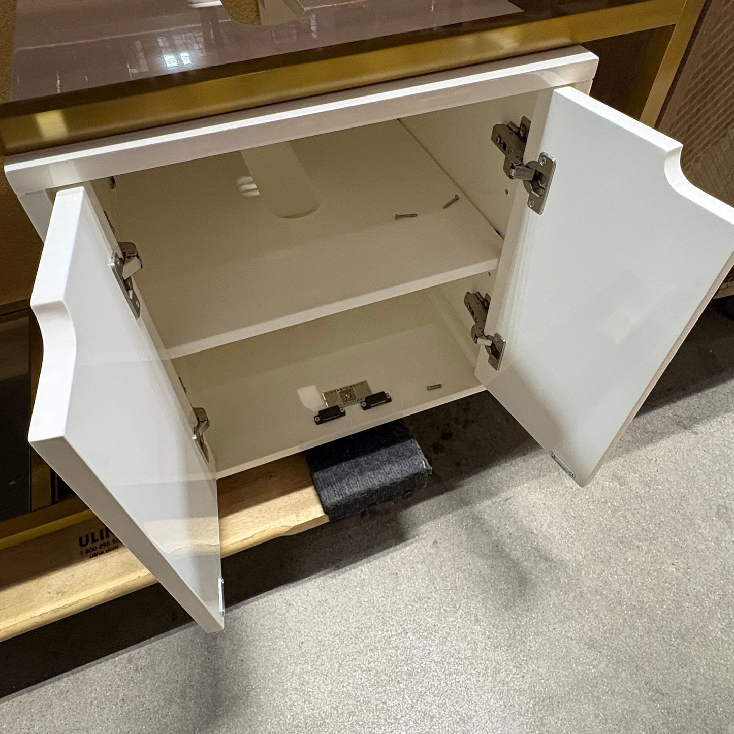 GDM Habitat for Humanity ReStore white bathroom vanity cabinet with open doors and gold countertop