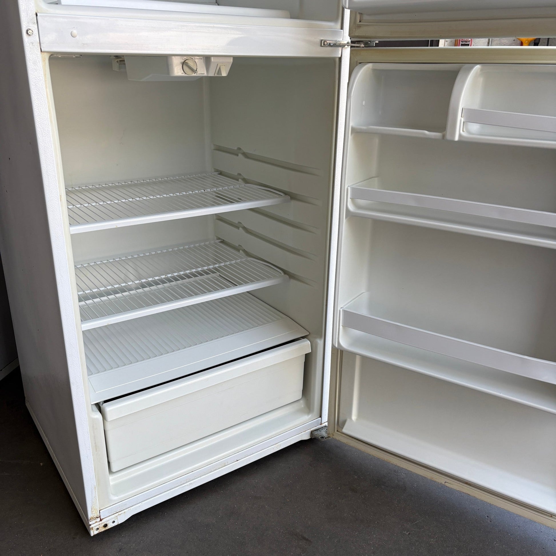 GDM Habitat for Humanity ReStore white Whirlpool top-freezer refrigerator interior with wire shelves and door bins.